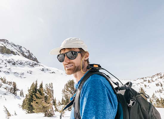 hiker in snowy mountain with sunski sun protection glasses