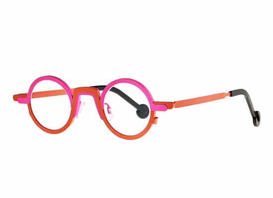 Playful round glasses with a thick pink and orange frame, adding a touch of eccentricity. theo brand