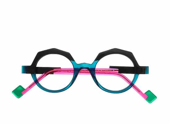 Extravagant style glasses with round black frames, pink and green temples and turquoise details.