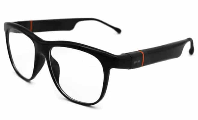 A close-up of a pair of Solos smart glasses with a sleek black frame, featuring subtle orange accents near the temples