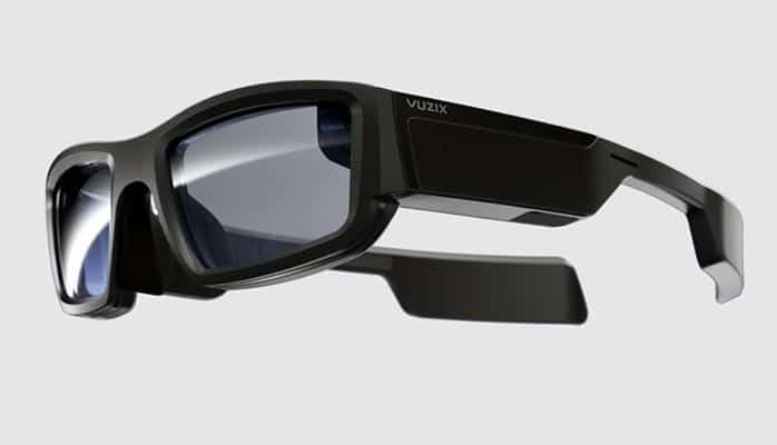 Une paire de lunettes de réalité augmentée Vuzix avec une monture noire robuste et des branches épaisses sur un fond blanc.