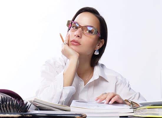 Femme en chemise blanche réfléchissant avec des lunettes à monture colorée en acétate. image mise en avant article