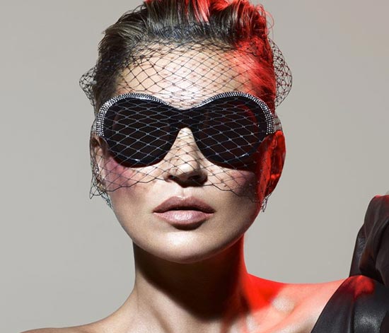 Fashion portrait of a woman wearing black oversized sunglasses with a mesh veil.