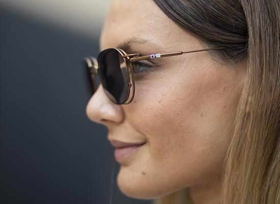Profil d'une femme portant des lunettes de vue ronde élégantes, avec un clip solaire easyclip de chez aspex dessus, soulignant un look moderne.