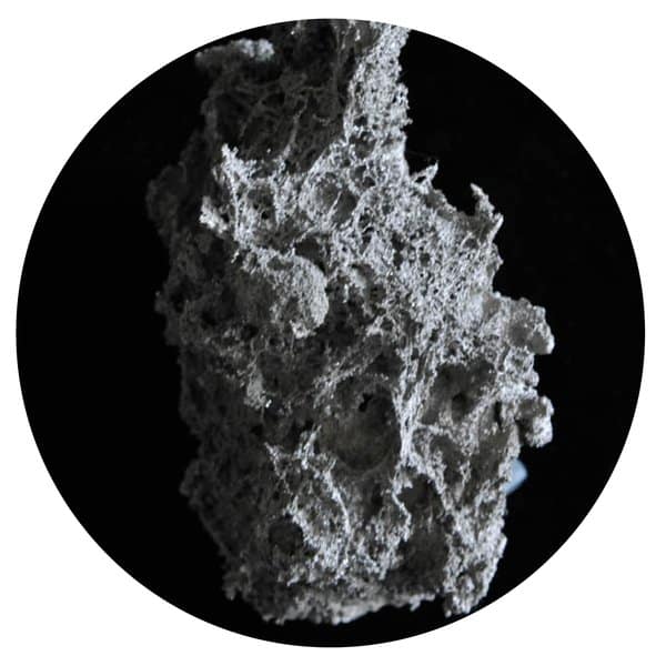 Textured mass of black titanium close-up on black background.