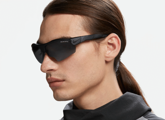 Homme avec des lunettes de soleil Nike noires de style sportif.