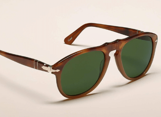 Persol sunglasses with brown frames and green lenses.